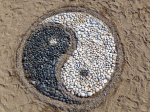 cailloux sur du sable représentant le symbole yin yang